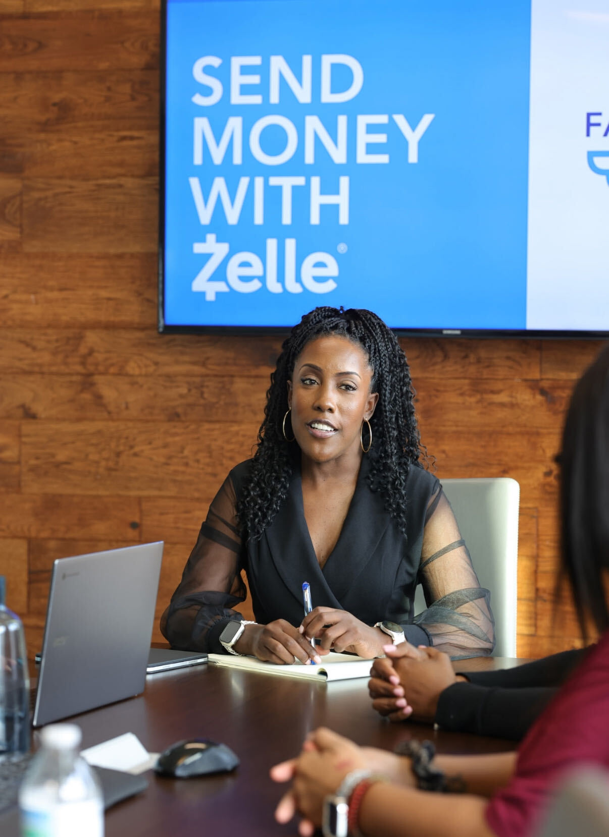 Mesia Crews in conversation at a conference table